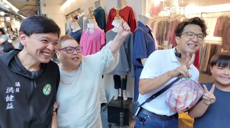 沈伯洋五分埔掃街受店家與民眾歡迎,手上拿著民眾送的雞蛋糕。(圖/翻攝畫面)