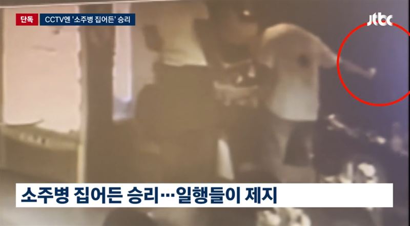 監視器畫面顯示，勝利曾拿起桌上的燒酒瓶並揮動。（圖／翻攝自JTBC）