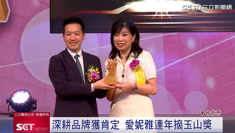 愛妮雅集團從總統府副秘書長何志偉手上,接下傑出企業獎。(圖/擷自三立新聞YT)
