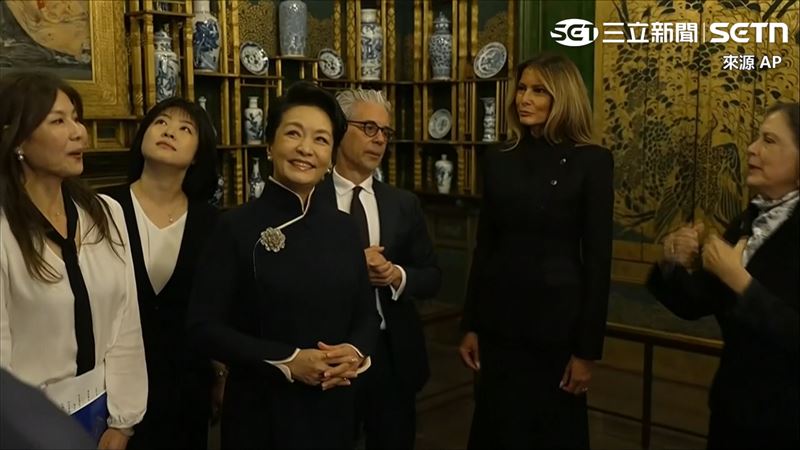 彭麗媛看展品時燦笑。(圖/AP授權)