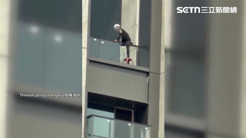 工作人員拿著塑膠椅先翻過玻璃圍欄,接著竟然直接踩上椅子施工,畫面驚險