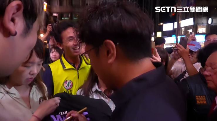 沈伯洋出席興雅福德宮中秋聯歡餐會,簽名邀約不斷,他也逐一回應。(圖/翻攝畫面)