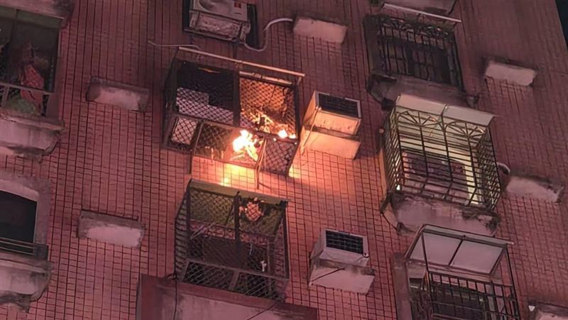 男子深夜在高雄新興區大樓下方施放爆竹煙火,火星飛濺引燃7樓及8樓陽台衣物遮光罩。(圖/翻攝畫面)
