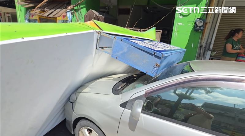 停放在路邊的車量無端遭招牌砸毀。(圖/記者朱俊傑攝影)