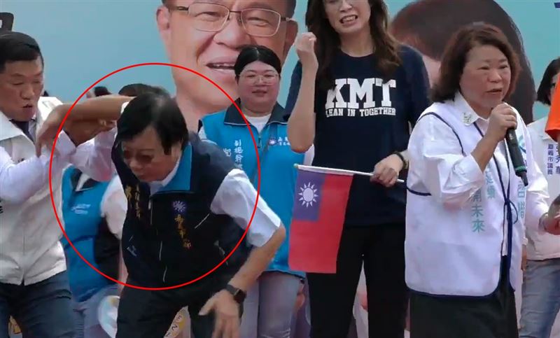 國民黨嘉義市黨部主委蔡明顯,疑似因天氣炎熱不適,下秒突然身體一軟,從舞台上墜落。(圖/翻攝自張啓楷臉書)