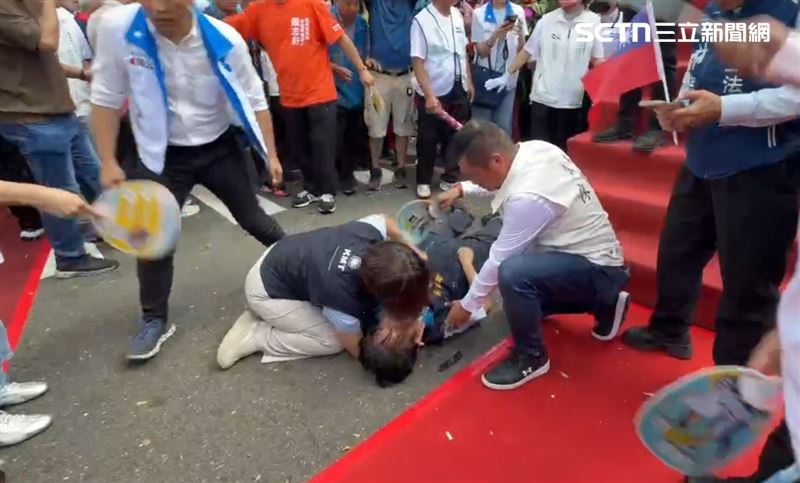 現場人員一擁而上,協助將頭部墊高,不斷搧風散熱。(圖/翻攝畫面)