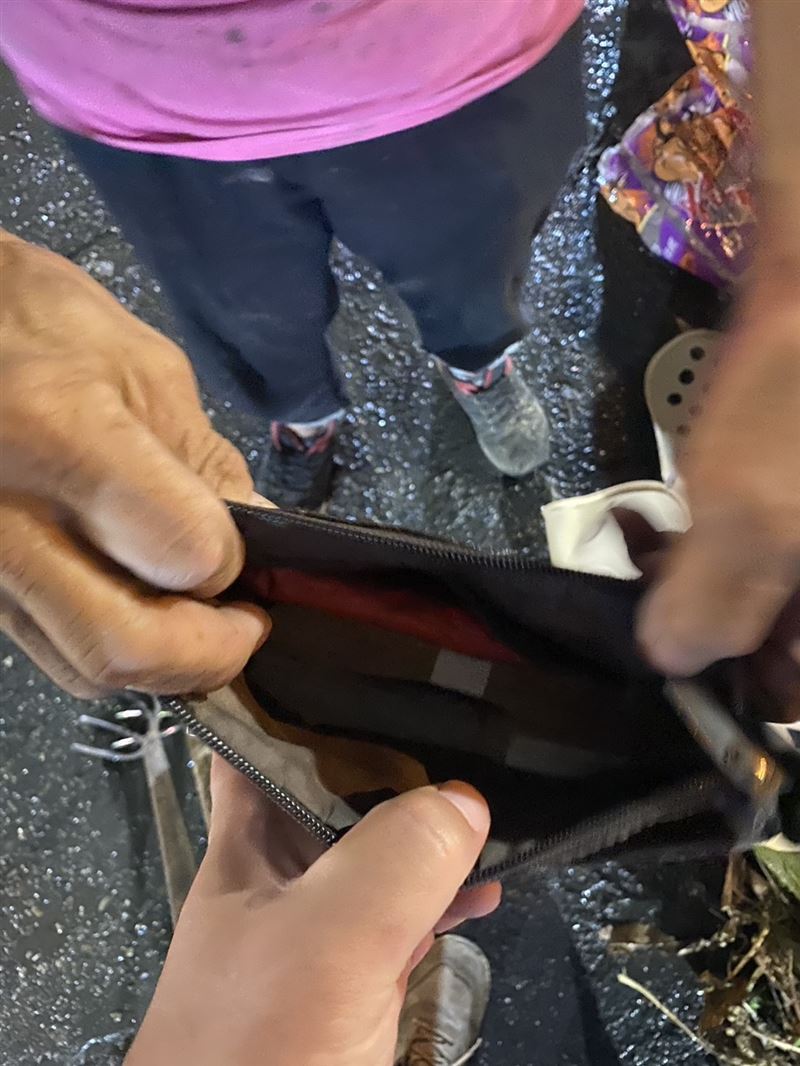 清潔隊員在垃圾堆中搜尋5分鐘左右,找回婦人皮包,20多萬現金完整無缺尋回。(圖/翻攝畫面)
