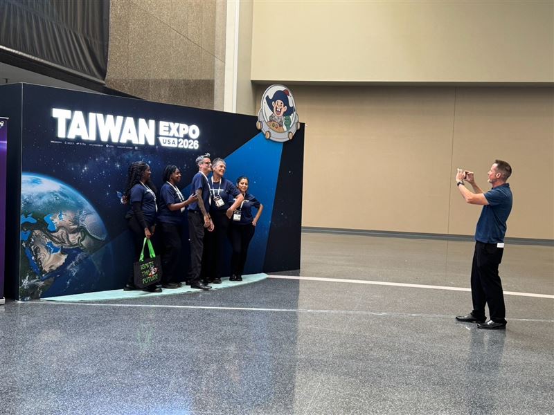 乖乖有趣的保庇意象,吸引外國參展商紛紛來到台灣形象展拍照區合影,主視覺上方的乖乖角色也活潑入鏡。(圖/乖乖提供)