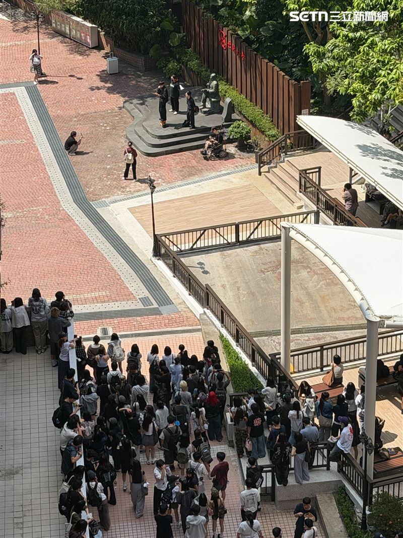 世新大學 2026 學年度推動行政體制變革,將行之有年的獨立系辦與系秘書業務收歸學院聯合辦公室及中央行政處室,並輔以 AI 客服與線上表單作為諮詢界面。中午 12時10分許,下課人潮在廣場中央停駐,上方舍我樓各層陽台陸續探出俯瞰的學生身影。(圖/世新大學學生提供)