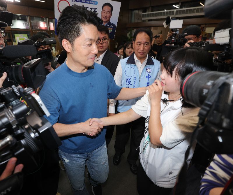 台北市長蔣萬安(前左)30日晚間出席南門市場平安宴,與台灣民眾黨台北市議員參選人吳怡萱(前右)握手致意