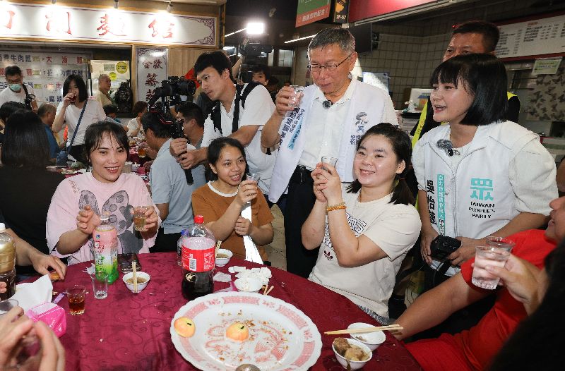 台灣民眾黨創黨主席柯文哲(後右2)30日晚間陪同黨籍台北市議員參選人吳怡萱(後右)出席南門市場平安宴,逐桌向民眾致意