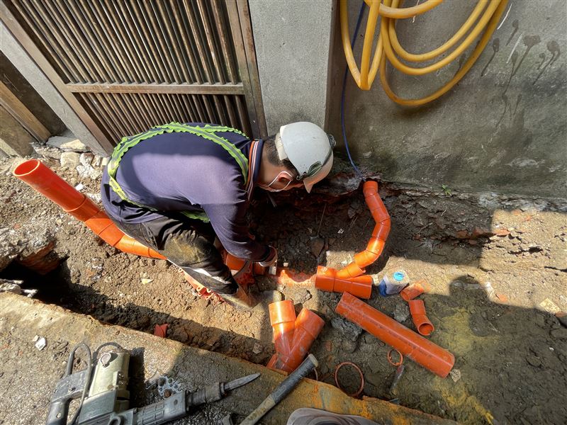施工人員將住家的污水管接入污水下水道系統,污水不再排入水溝造成惡臭。(圖/新北市政府提供)