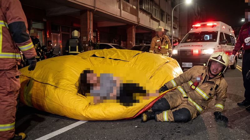 高雄市苓雅區自強路今天(3日)凌晨,警消派員救護一名不明原因從高處跌落的女子,她掉落時,恰巧壓傷下方佈置氣墊的消防員,導致2人都送醫。(示意圖/AI製圖)