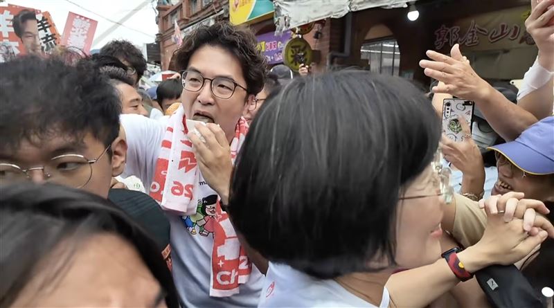 沈伯洋邊掃街邊啃金牛角(圖/翻攝畫面)
