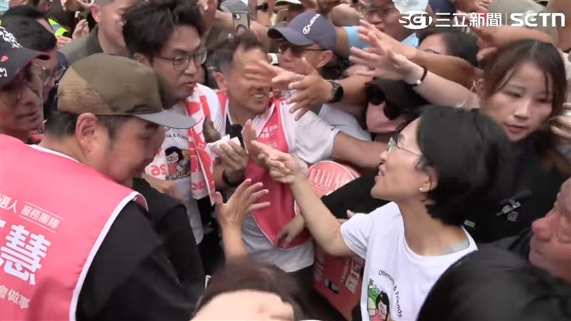 沈伯洋邊啃金牛角邊掃街,逗趣模樣讓蘇巧慧忍不住笑出來(圖/翻攝畫面)
