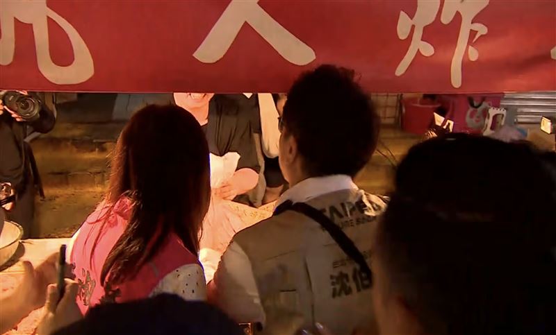 攤商請沈伯洋吃炸雞，見到沈伯洋便大喊：市長，請你吃雞腿！沈伯洋也在店家招牌上簽名。（圖／翻攝畫面）