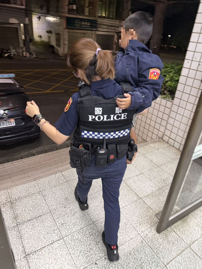 員警幫男童披上警用外套，在迷路地點附近一公里處挨家挨戶找尋男童家人。(圖/翻攝畫面)