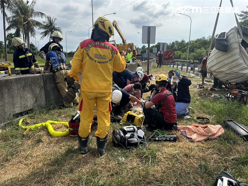 新營預拌水泥車失控翻落邊坡,駕駛受困變形車艙,醫護奔現場打點滴搶命。(圖/翻攝畫面)