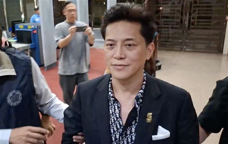 陳力新被移送北檢時，穿著整套時尚西裝，面露微笑。（圖／翻攝畫面）