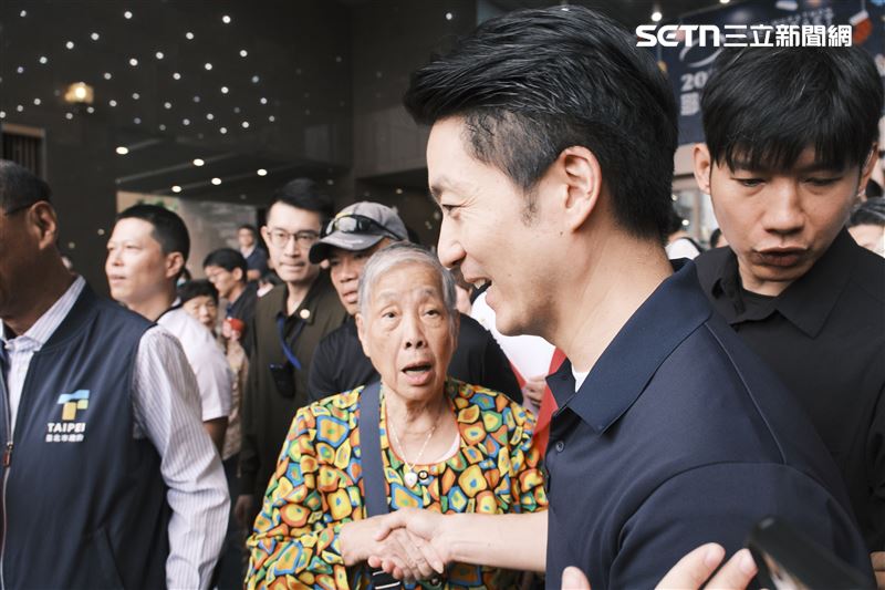 蔣萬安出席市府國慶升旗活動,不少長輩和他握手、合影,還有長輩大喊「市長加油」。(圖/記者楊士誼攝影)