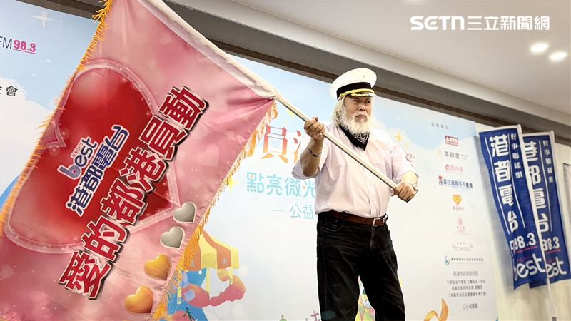 「動員港都的愛」公益活動32年不間斷,副董事長孫國祥揮舞愛心旗幟。(圖/記者簡榮良攝影)