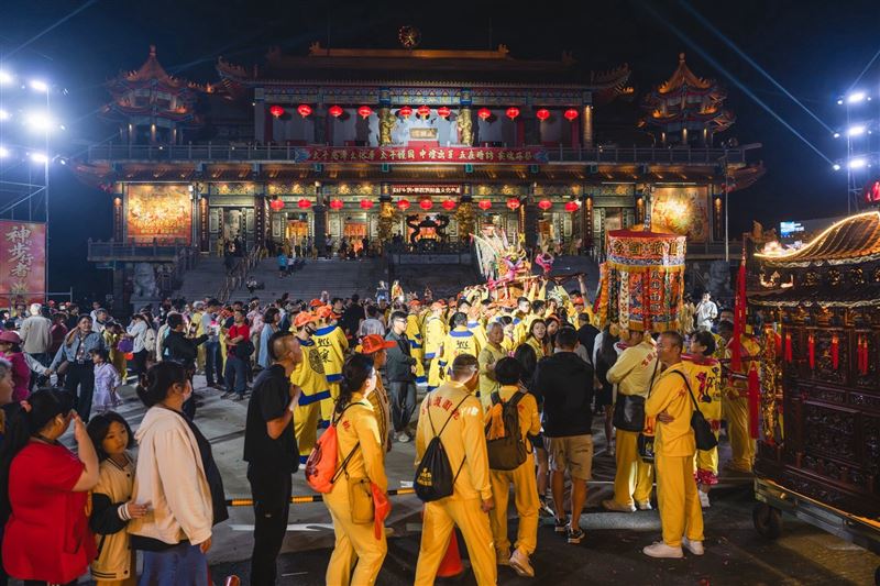 回宮當晚，鑽轎底人潮從廟埕排到國際路，郭宏睿、草爺及廟方人士分送壽桃、壓轎金等。（圖／陳乃瑋攝影、桃園護國宮提供）