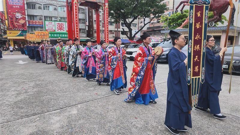 全真派高雄普化院與高雄關帝廟合辦戒典,道長與身穿藏青道衣的戒子們手持幡旗寶蓋依序前行,迎請臨壇大典場面肅穆。(圖/高市普化院提供)