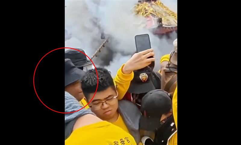 放炮之際,身穿黃色虎爺會制服、頭戴漁夫帽的男子硬是往前擠,穿越人牆。(圖/翻攝自宗教爆報臉書)