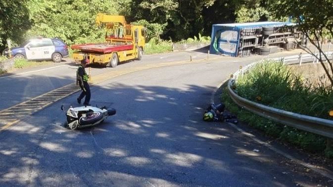 新北坪林區北宜公路，清晨發生貨車翻覆事故，之後陳姓員警交管，遭蔡男騎乘重機撞擊，2件車禍事故釀4人受傷送醫。（圖／翻攝畫面）