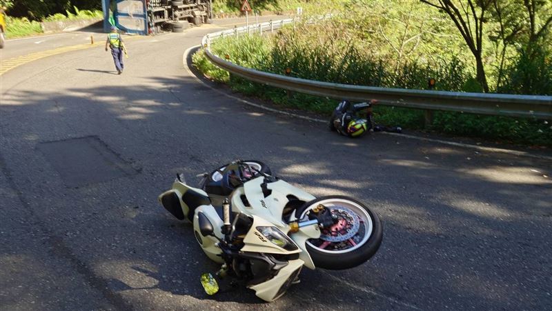 新北坪林區北宜公路，清晨發生貨車翻覆事故，之後陳姓員警交管，遭蔡男騎乘重機撞擊，2件車禍事故釀4人受傷送醫。（圖／翻攝畫面）