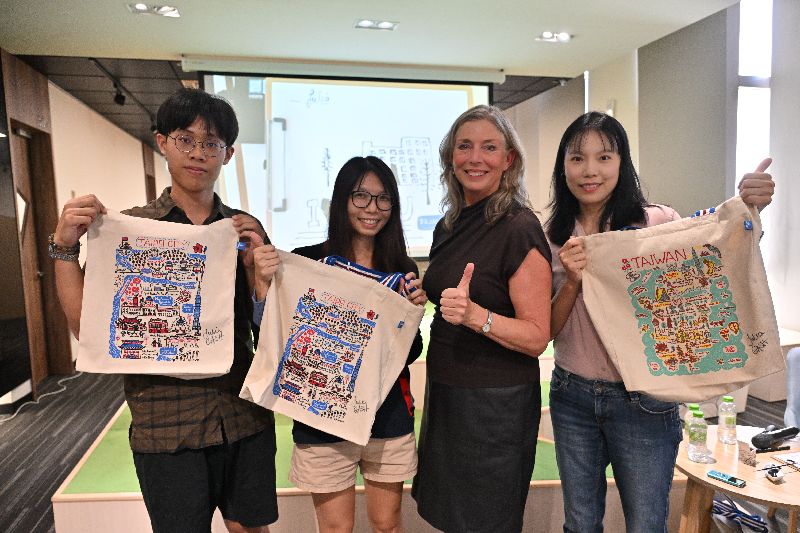 陽明交通大學21日發布新聞稿指出,英籍設計師蓋西(Julia Gash)(右2)以色彩鮮明的手繪線條,搭配獨特式的地景插畫風格聞名。陽明交大將與蓋西合作,推出多款紀念商品,盼透過插畫,重新訴說校園故事。(陽明交大提供)