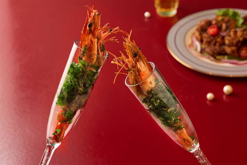 「毛毛蟲海大蝦」將鮮蝦裹上菠菜麵衣酥炸,並以香檳杯盛裝,重現節目中的上桌方式。(圖/饗賓集團提供)