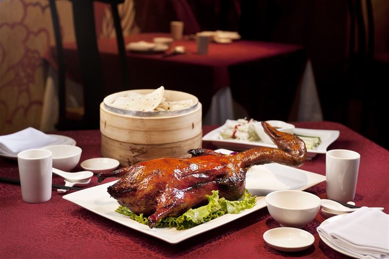 王朝中餐廳招牌「凱撒桃木片皮鴨四吃」,以片鴨、鴨腿件、銀芽鴨絲炒餅及鴨粥四種吃法呈現多元風味,須於三天前預訂。(圖/飯店旅宿業者提供)