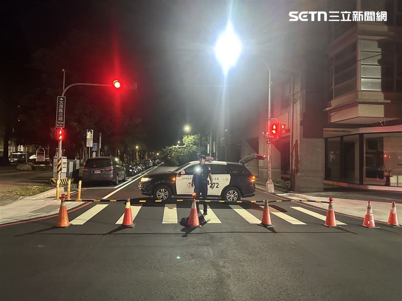 員警頂著強烈風勢在路口迅速擺設交通錐與警示燈，實施雙向車流疏導與警戒管制。（圖／翻攝畫面）
