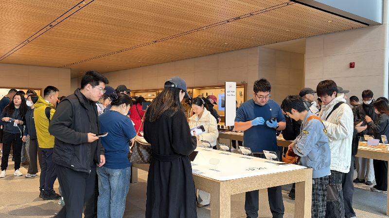 蘋果首款摺疊手機iPhone Duo 23日首度開售。圖為北京三里屯門市的中國消費者試用新機