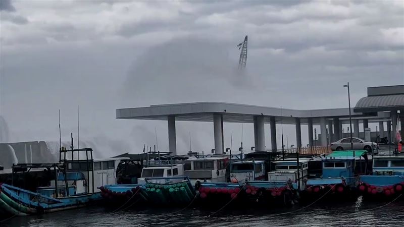 台東富岡漁港一輛吊掛消波塊的大型吊車遭巨浪擊沉入海。（圖／翻攝畫面）