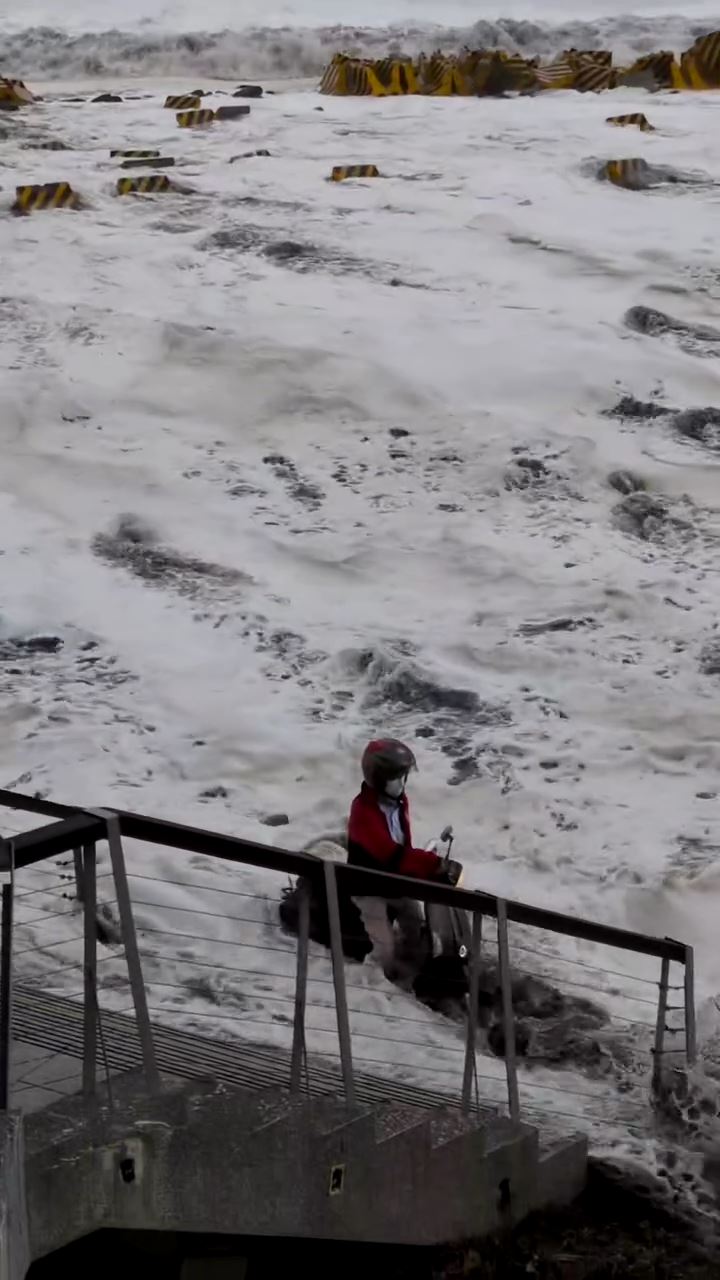 男子騎車經過已淹水的台東海濱公園時,人車被突來的大浪擊沉,騎士瞬間被海水滅頂。(圖/翻攝畫面)