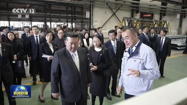 金正恩參訪丹東汽車製造廠生產線,認真聽技術人員解說。(圖/翻攝央視新聞聯播)