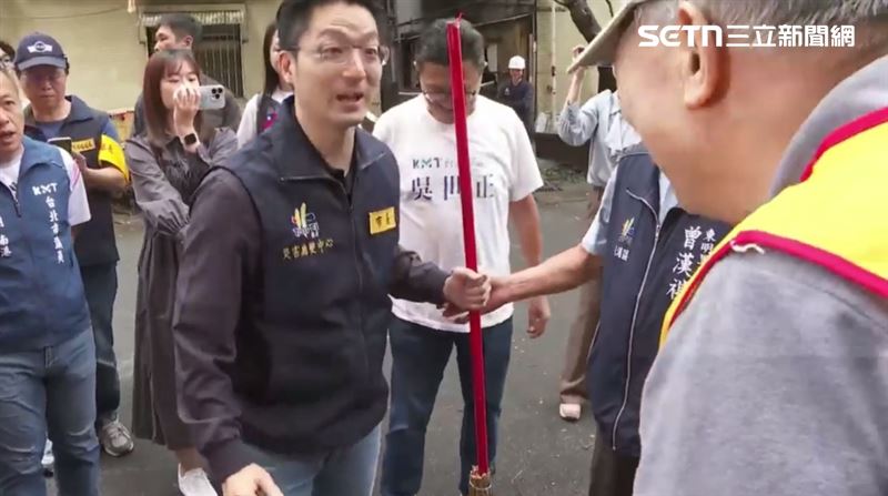 蔣萬安接過掃把幫忙掃樹葉(圖/翻攝畫面)