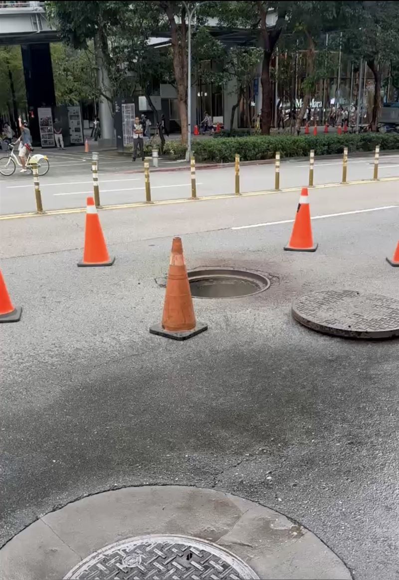 台北市信義區松智路上今(25日)下午傳出有人孔蓋爆開,現場飄出白煙。(圖/翻攝畫面)