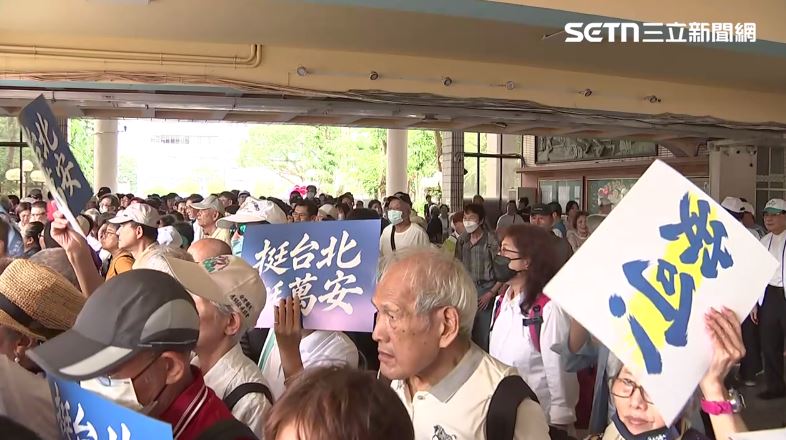 藍營支持者們手持挺萬安的手板排隊進場。(圖/翻攝畫面)