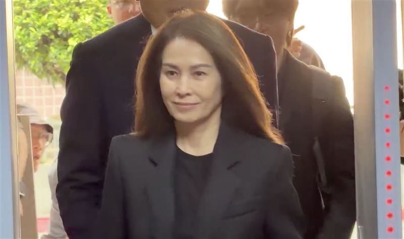 高金素梅一身黑衣黑褲抵達台北地院，被追問是否認罪，微笑不語。（圖／翻攝畫面）