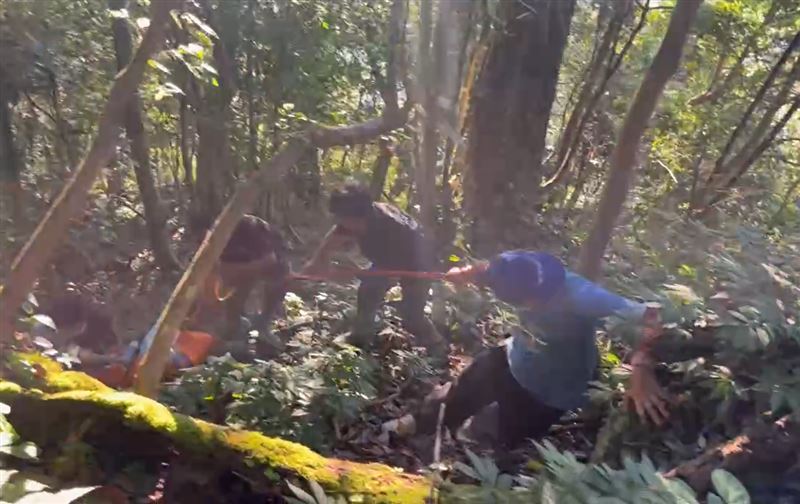 男子陳屍在地勢陡峭的山區，警義消人員耗費5小時才將遺體順利運下山。(圖／翻攝畫面)