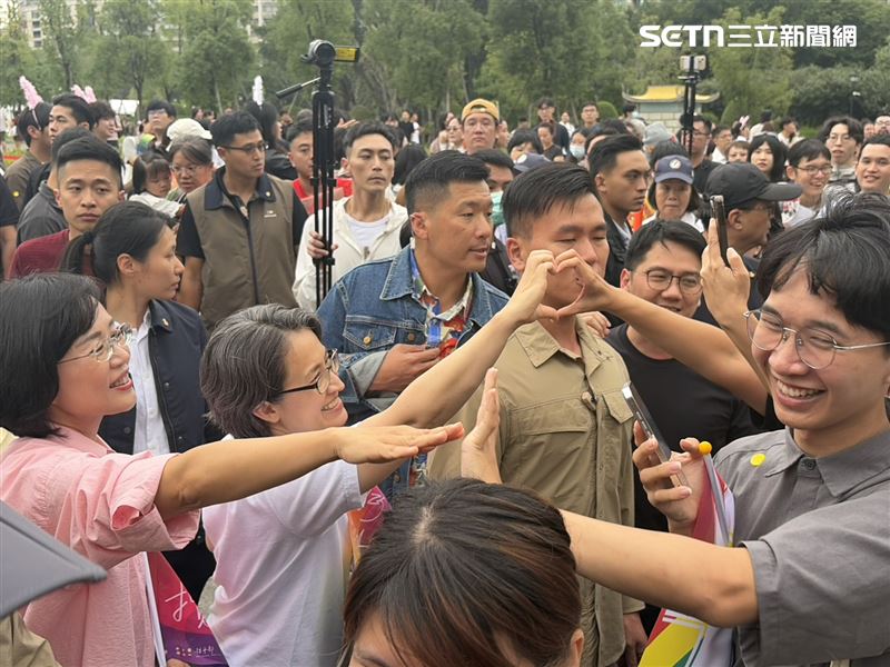 副總統蕭美琴在仁愛路旁揮舞彩虹旗，向上街遊行的民眾打招呼，更引來不少遊行民眾排隊握手。（圖／記者簡浩正攝影）